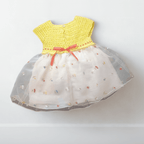 Vue de dos de la robe bébé sur mannequin. Détail de la fermeture par boutons sur le haut en crochet jaune et du nœud en ruban rouge à la taille.