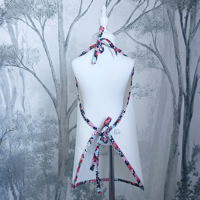 Vue de dos du tablier enfant montrant le système d'attache réglable par liens à nouer au cou et à la taille. Biais fleuri japonais.