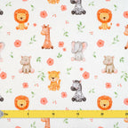 Zoom sur un tissu blanc aux motifs d'animaux de la savane en aquarelle (lion, girafe, éléphant, zèbre, hippopotame) avec des petites fleurs roses et des feuilles vertes, accompagné d'une règle de mesure jaune pour l'échelle.