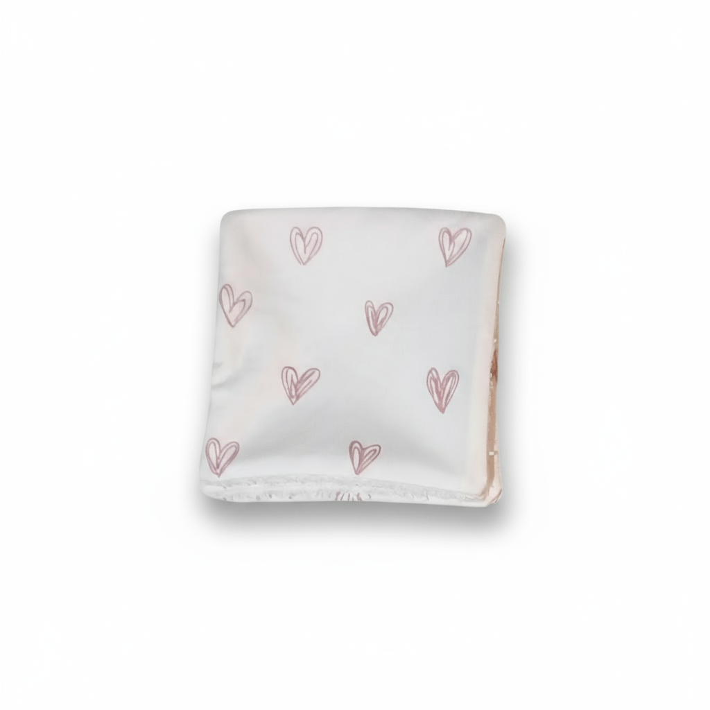 Gros plan sur le tissu coton motif cœurs roses certifié Oeko-Tex.