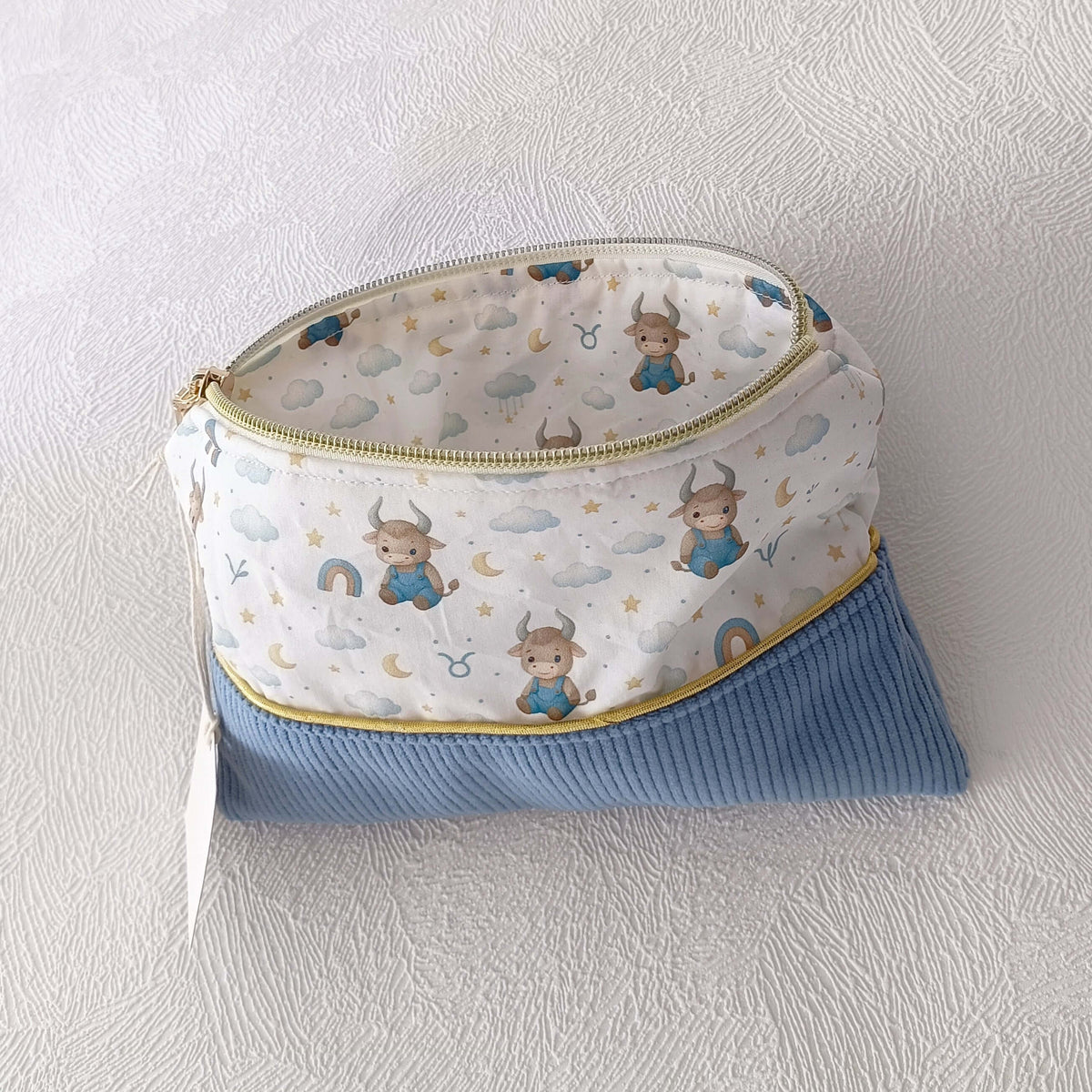 Trousse enfant personnalisable avec tissu motif taureau, nuages et ciel, base bleue en velours côtelé.
