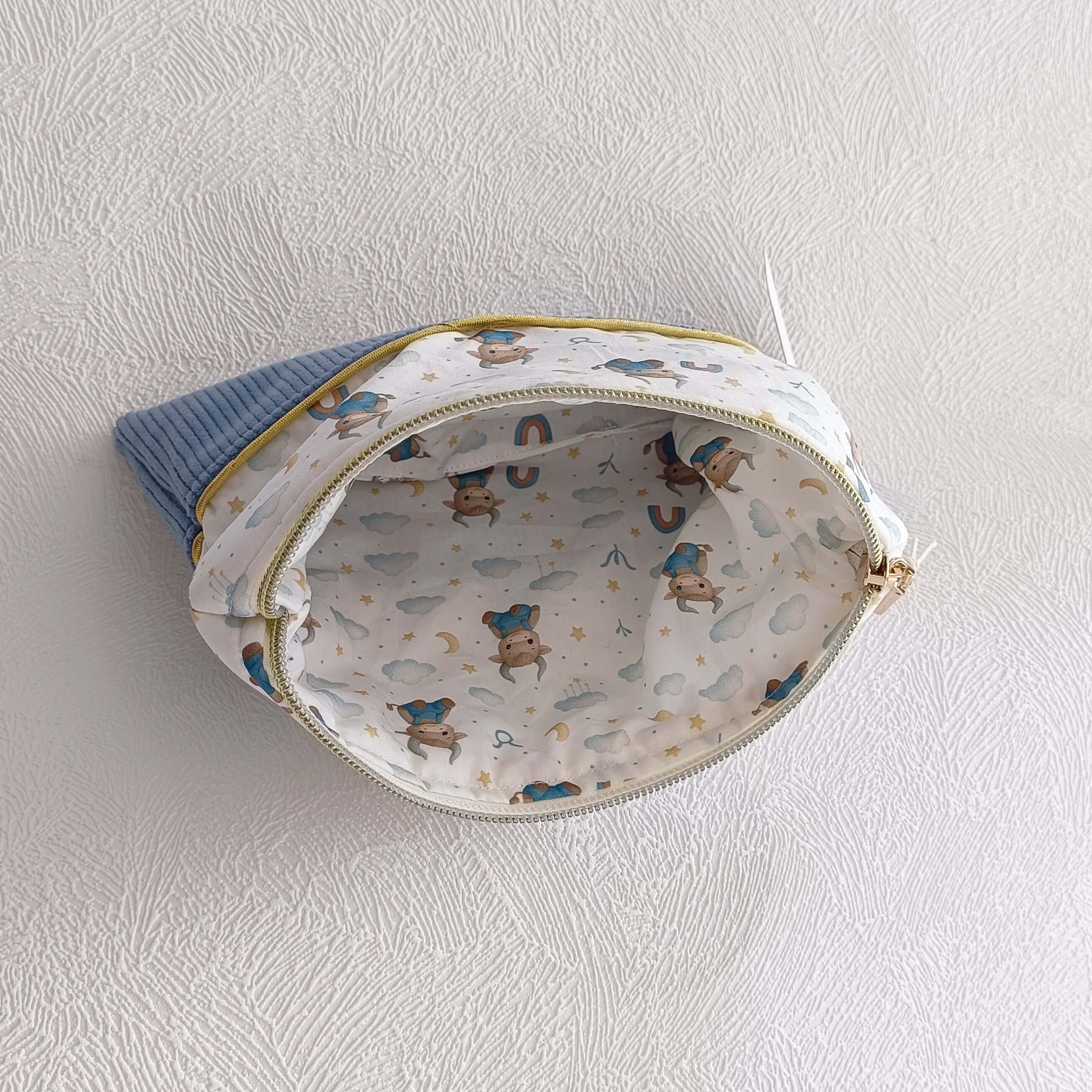 Vue intérieure de la trousse artisanale en velours côtelé bleu — doublure motif taureau zodiac aquarelle étoiles et nuages, faite main
